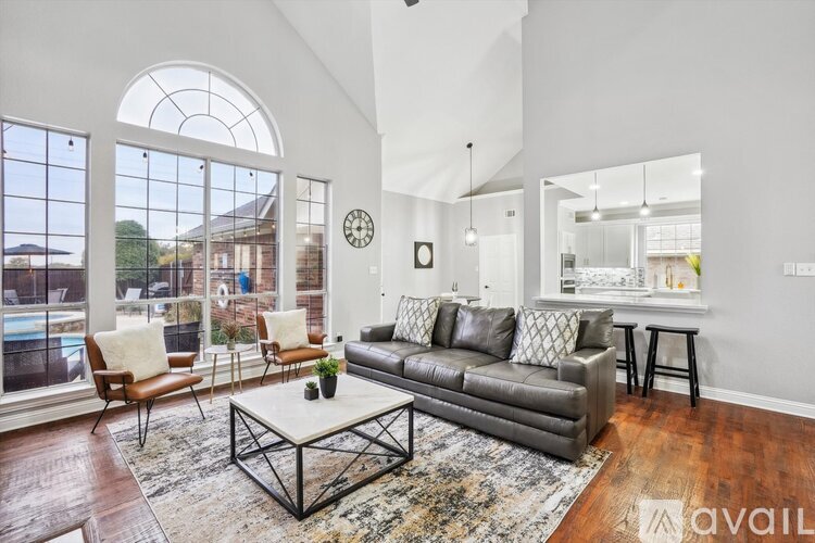 A living room with a grey couch and a large window.