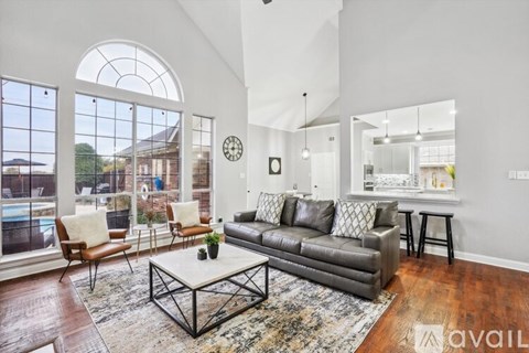 A living room with a grey couch and a large window.