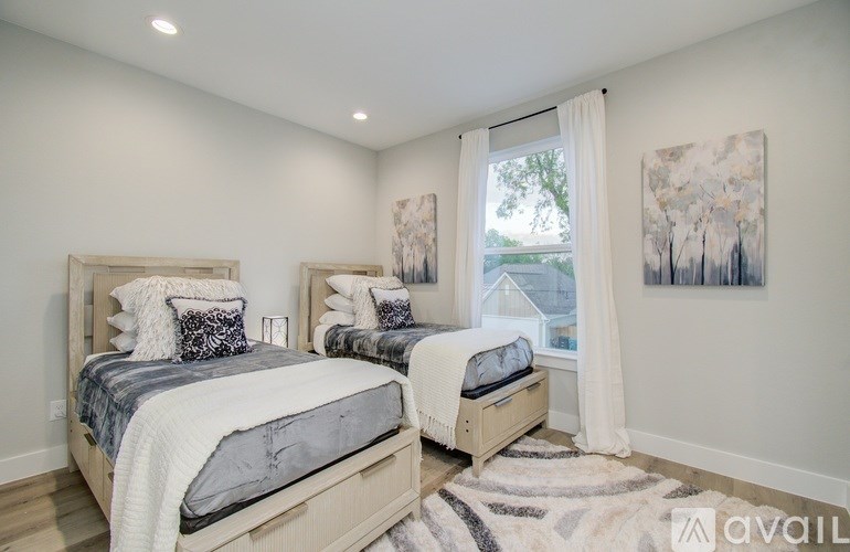 A bedroom with two beds and a window.