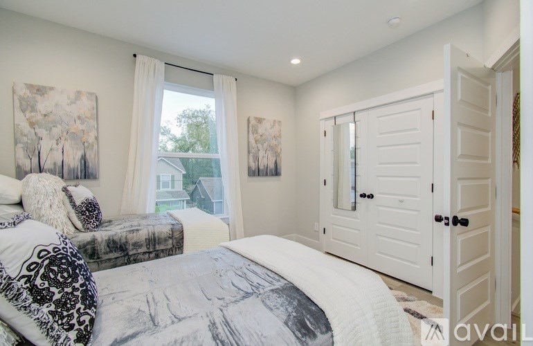 A bedroom with a large bed and two paintings on the wall.