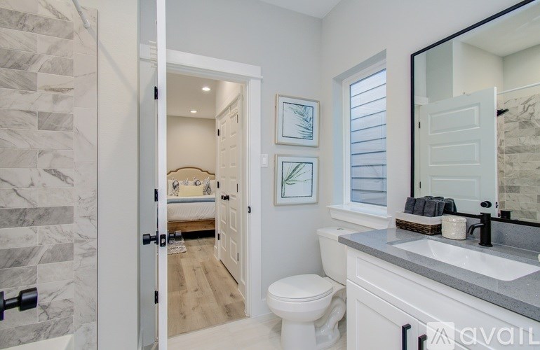 A bathroom with a toilet, sink, and mirror.