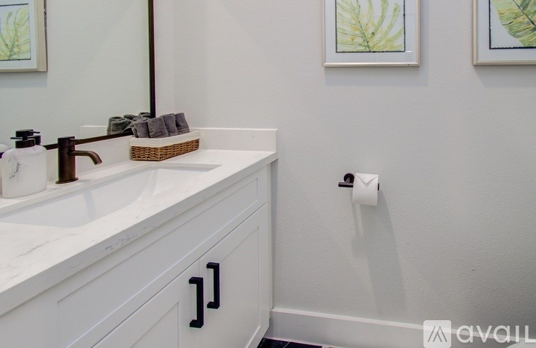 A bathroom with a white sink and a mirror.