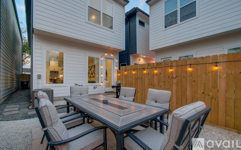 A patio with a table and chairs is set up outside a house.