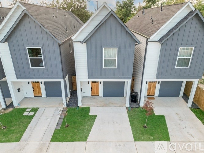 A house with grey siding and a brown roof is for sale.