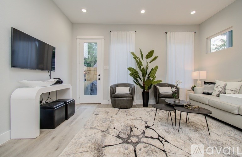 A living room with a flat screen TV mounted on the wall.