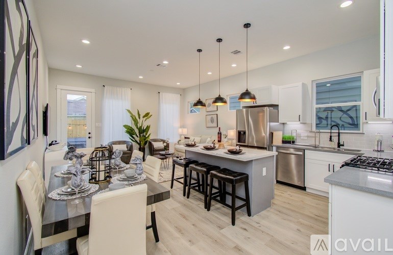 A modern kitchen with a dining table set for two.