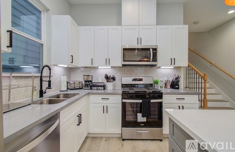 A kitchen with white cabinets and stainless steel appliances.
