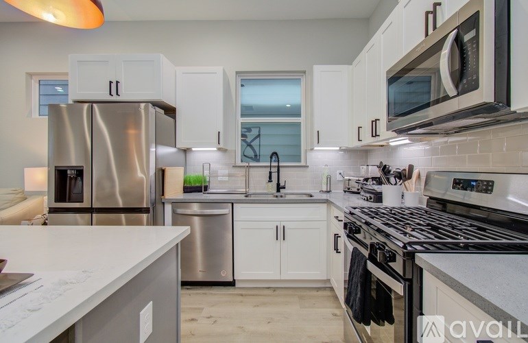 A kitchen with white cabinets and stainless steel appliances.