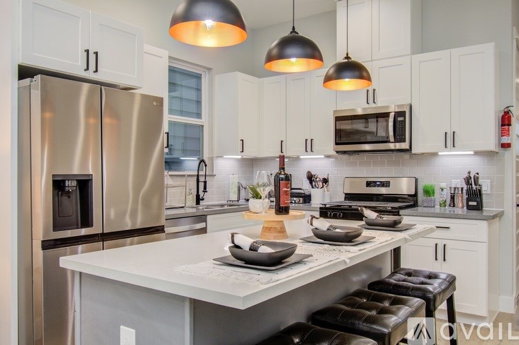 A modern kitchen with a white countertop and stainless steel appliances.