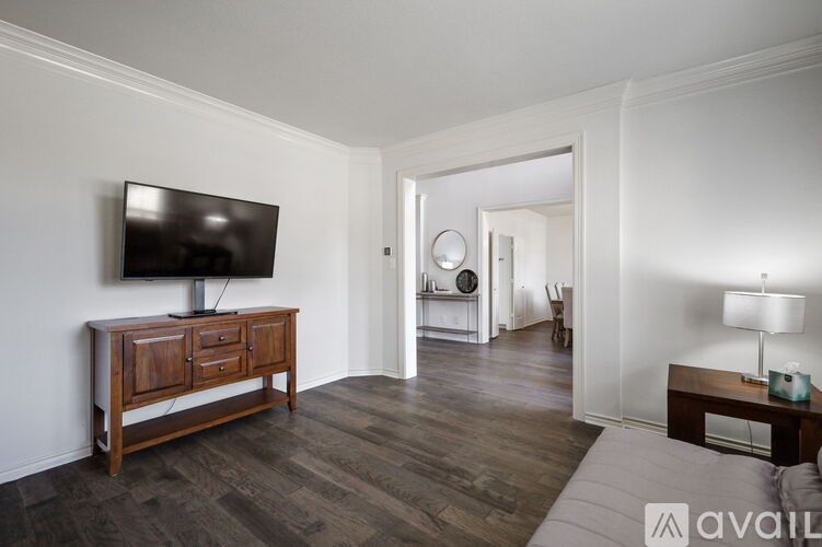 A room with a wooden cabinet and a television on it.