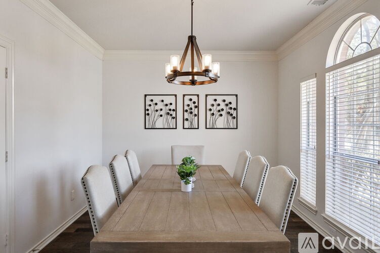 A wooden dining table with chairs and a hanging light fixture.