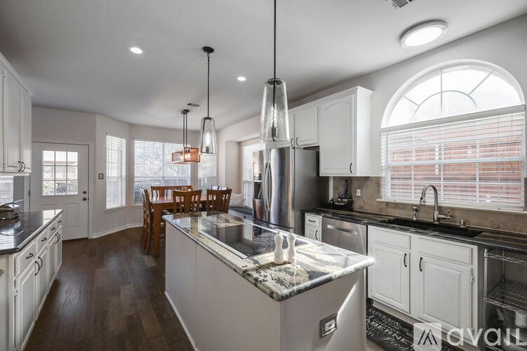 A kitchen with a large island and a dining table.