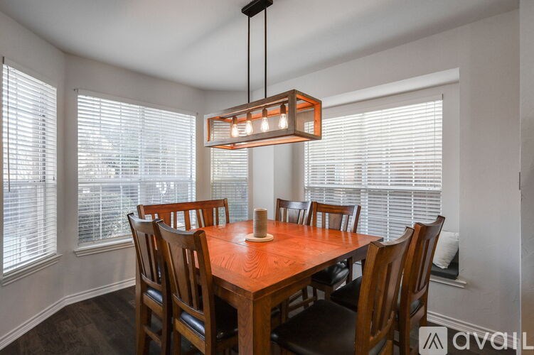 A dining room with a wooden table and chairs.