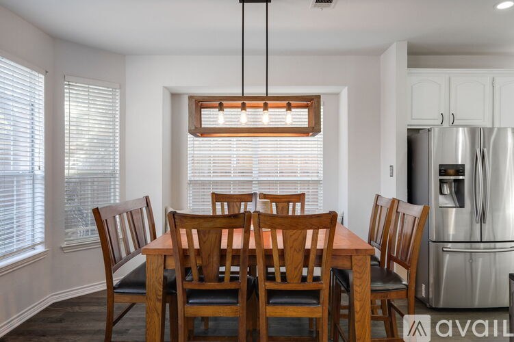 A dining room with a wooden table and chairs.