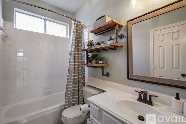A bathroom with a tub, sink, and mirror.