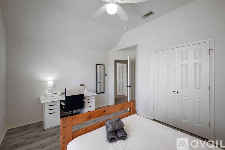 A bedroom with a bed, desk, and chair.