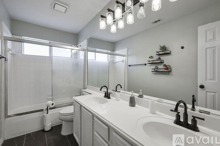 A bathroom with a white sink and a toilet.