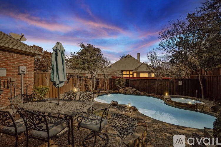A backyard with a pool and patio furniture.