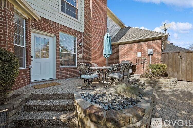 A house with a patio and a stone wall.