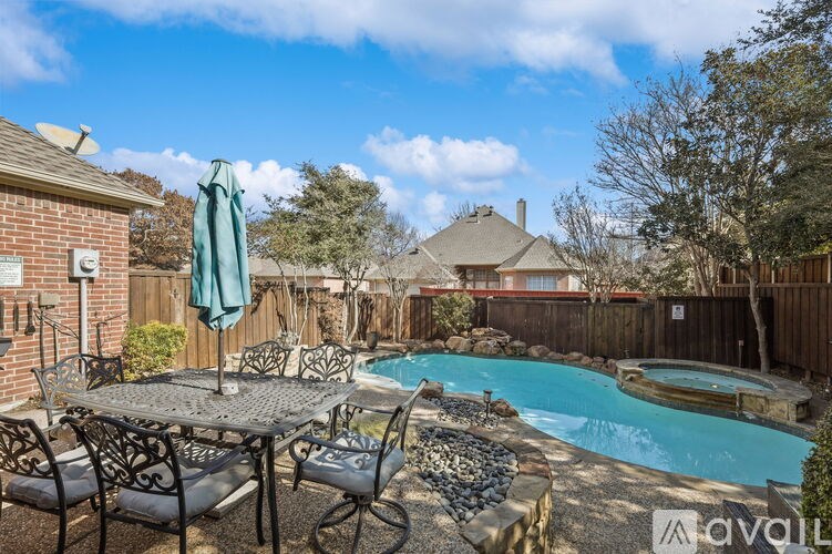 A backyard with a pool and patio furniture.