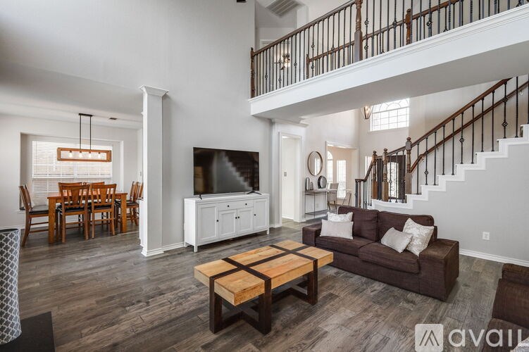 A living room with a wooden floor and a staircase.