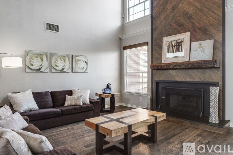 A living room with a brown couch and a fireplace.