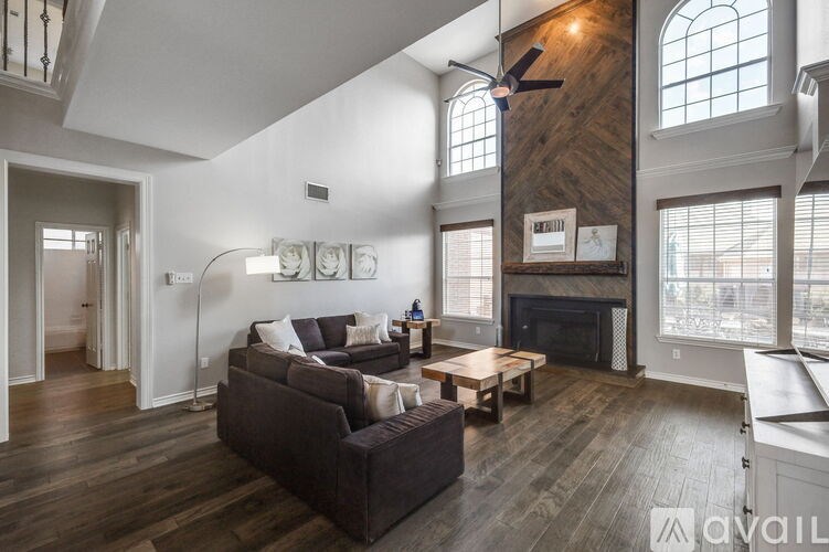 A living room with a dark brown couch and a fireplace.