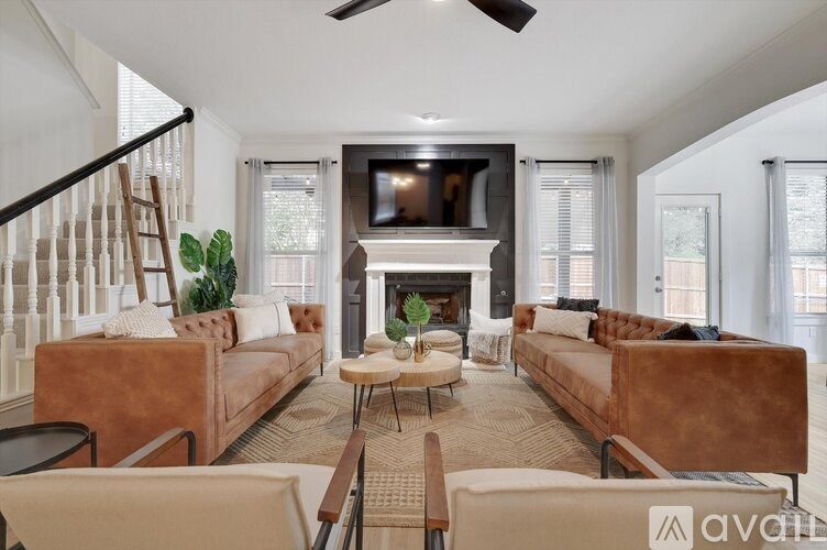 A living room with a brown couch, a fireplace, and a television.