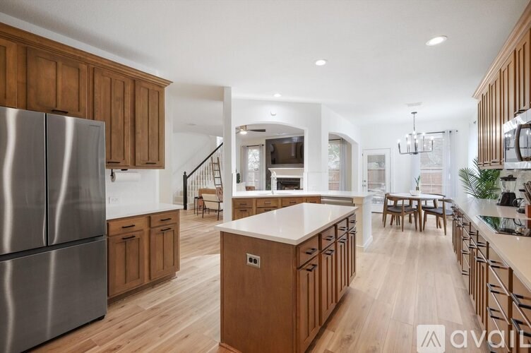 A modern kitchen with wooden cabinets and a stainless steel refrigerator.