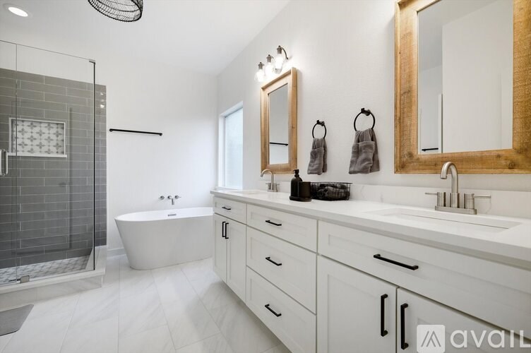 A modern bathroom with a white tub and a glass shower.