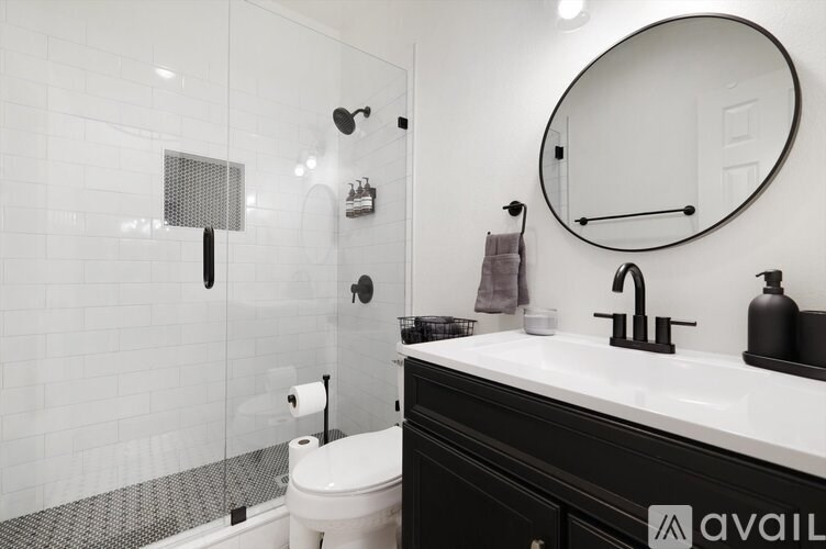 A bathroom with a toilet, sink, and shower.