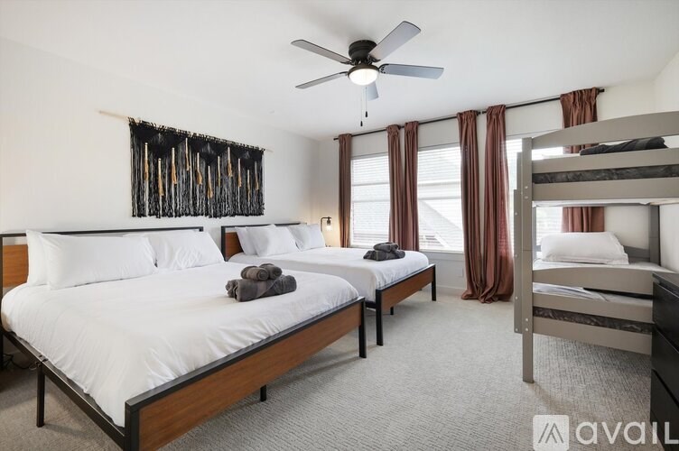 A bedroom with two beds and a ceiling fan.