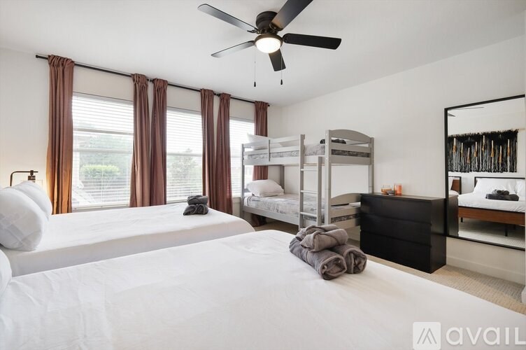 A bedroom with a large bed, a bunk bed, and a dresser.