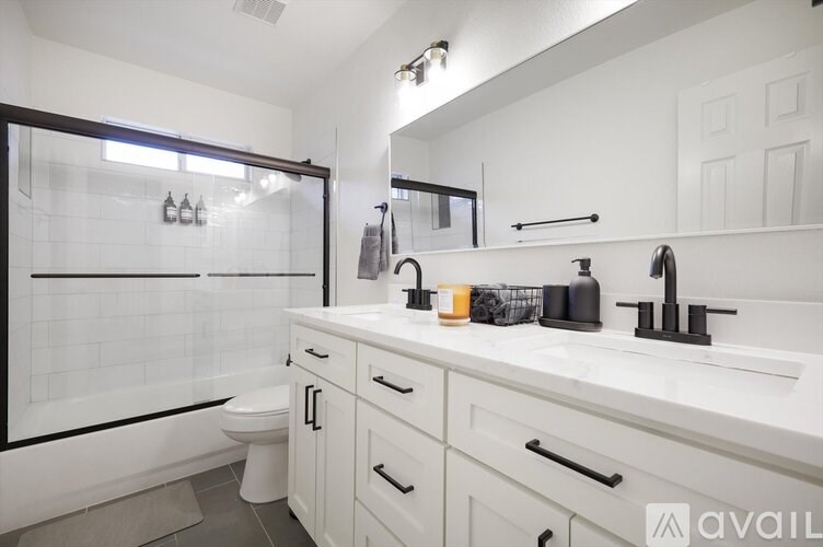 A bathroom with a white toilet, sink, and a glass shower door.