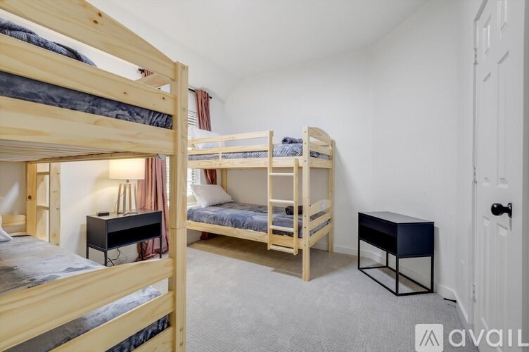 A bedroom with two bunk beds and a small table.