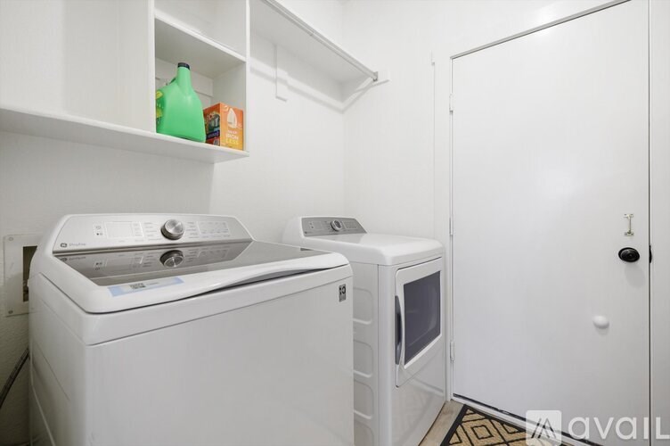 A white washing machine and dryer in a small laundry room.