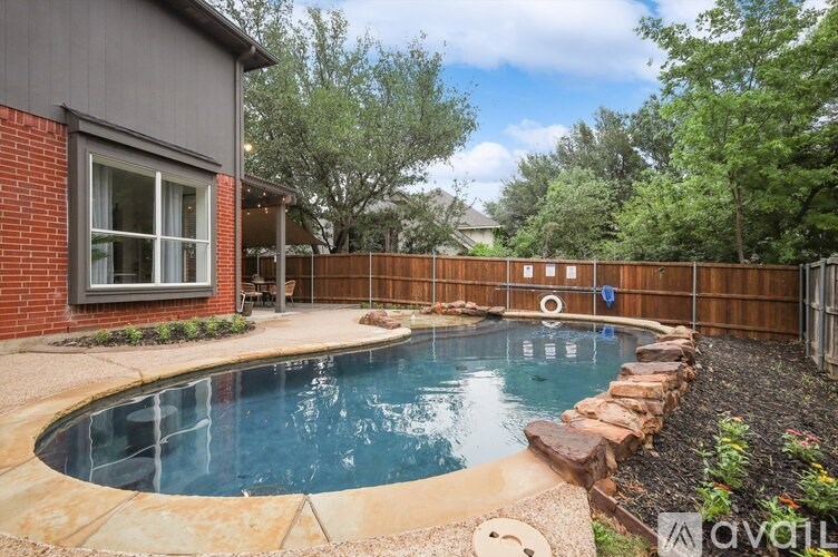 A backyard with a small pool and a wooden fence.