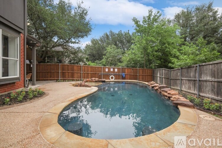 A backyard with a pool and a wooden fence.