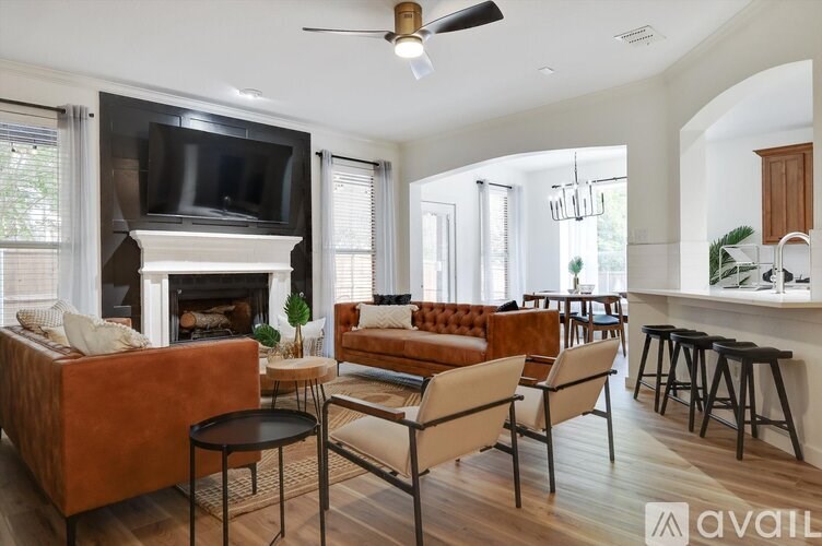 A living room with a fireplace and a television mounted above it.
