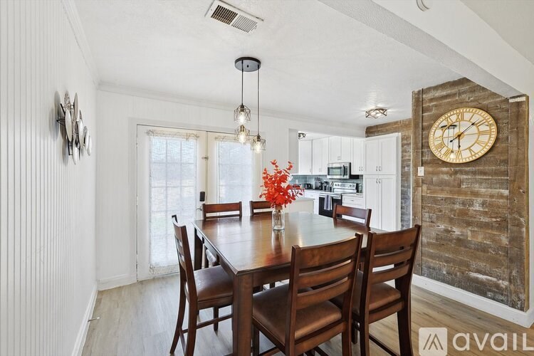 A dining room with a wooden table and chairs.