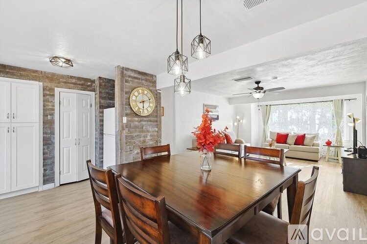 A dining room with a wooden table and chairs.