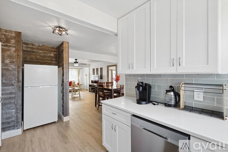 A kitchen with white cabinets and a white fridge.
