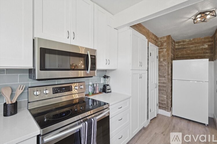 A kitchen with white cabinets and a stainless steel oven and microwave.