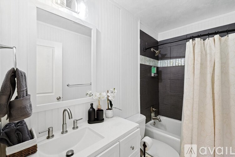 A bathroom with a white sink and a white bathtub.