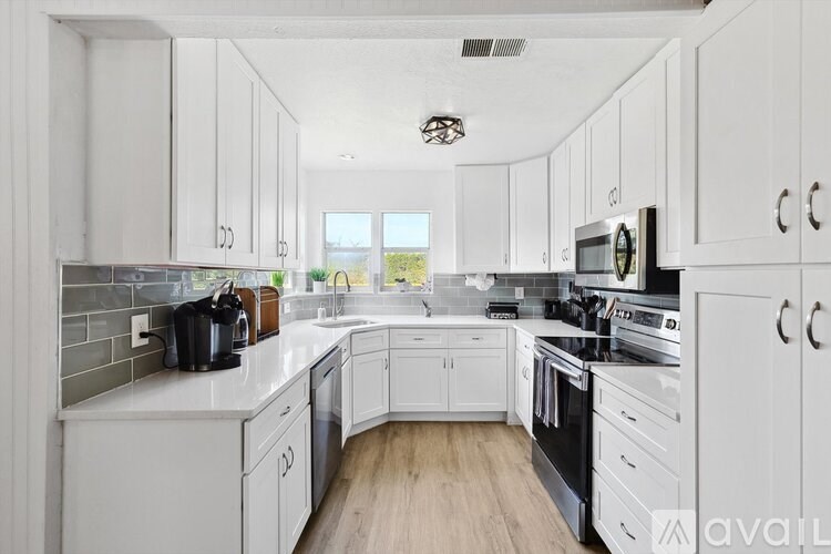 A kitchen with white cabinets and appliances.