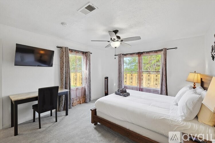 A bedroom with a bed, desk, and chair.