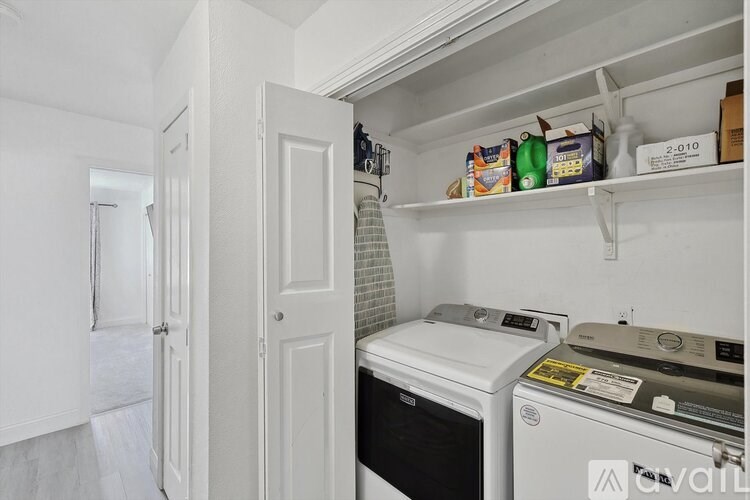 A white kitchen with a white fridge and a white washing machine.