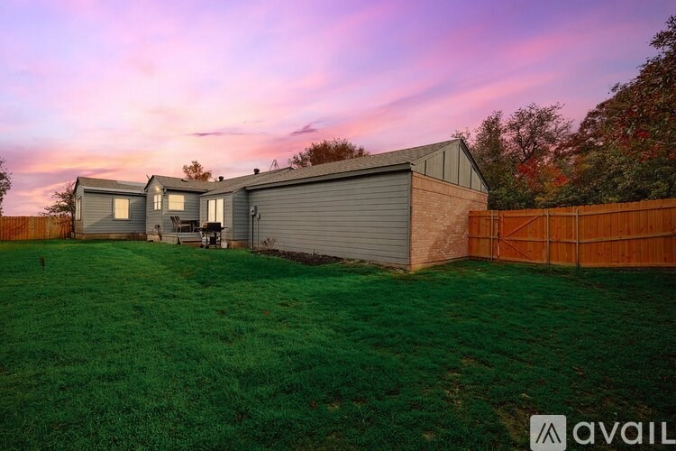 A house with a garage and a fence in front of it.