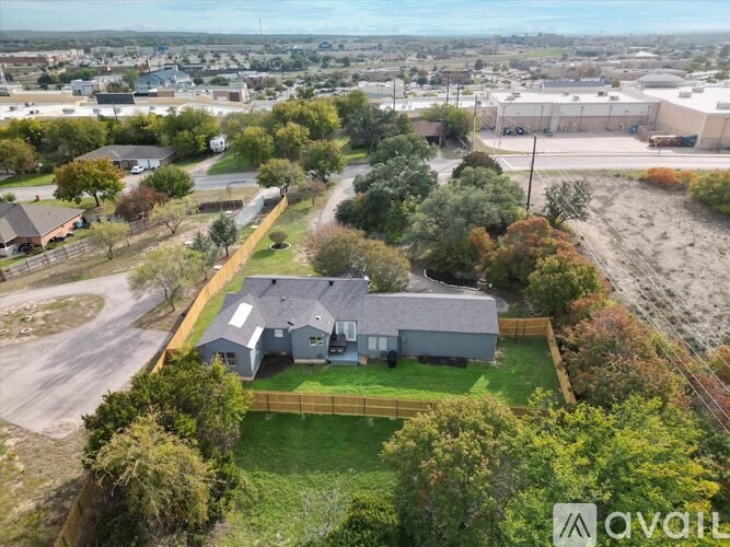 A large grey house with a green lawn in front of it.