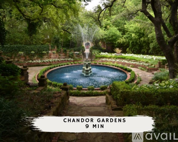 A beautiful garden with a fountain in the middle surrounded by greenery.